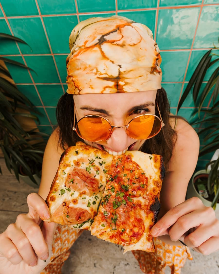 Biting into a crispy Roman-style square slice