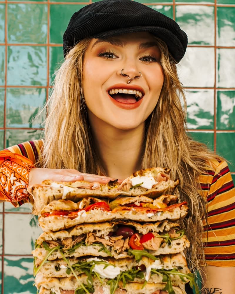 Biting into a stack of Roman-style slices